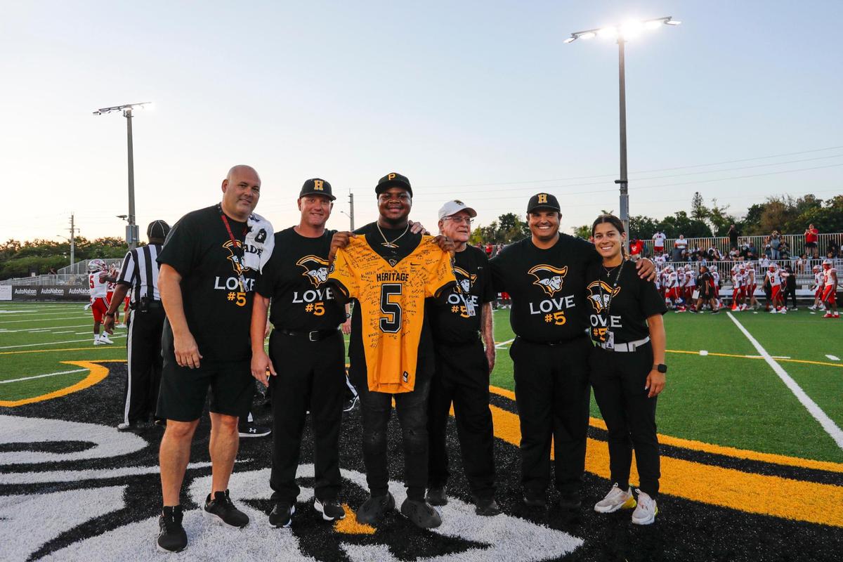 American Heritage football player Timothy Burroughs-Love is photographed with the team’s medical team after been recognized with jersey signed by his teammates during a ceremony prior to the game against St. John’s (Maryland) at American Heritage School in Plantation, Florida on Saturday, August 26, 2023. Burroughs-Love collapsed on the sideline during the first quarter of last week’s preseason game between Heritage and Miami Booker T. Washington at Traz Powell Stadium in North Miami.