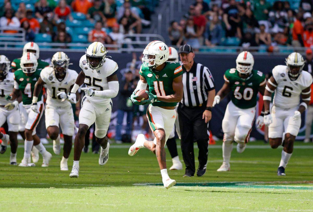 Miami Hurricanes wide receiver Charleston Rambo (11) runs with the football against the Georgia Tech Yellow Jackets during the first quarter of their ACC football game at Hard Rock Stadium on Saturday, November 6, 2021 in Miami Gardens, Florida.