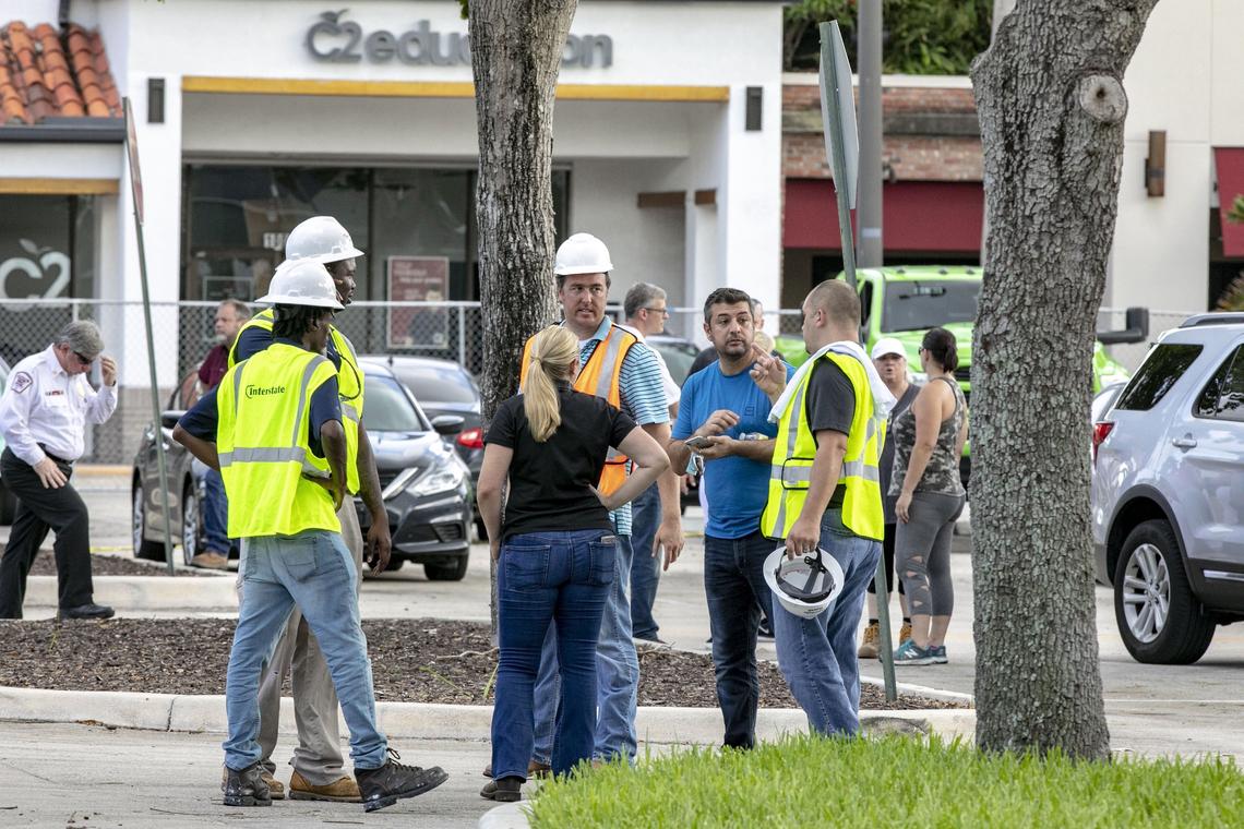 Clean-up crews and authorities speak with business owners and people who left their belongings after the explosion, in the parking lot at the site of the explosion across the street from the Fountains Plaza in Plantation, Florida on Sunday July 7, 2019.