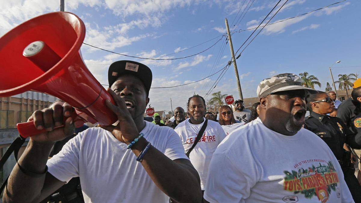  Dwight C. Wells, left, and James Dayton walk with the City of Miami police department and the community on Wednesday, April 11, 2018, due to recent shootings in Liberty City, Miami.