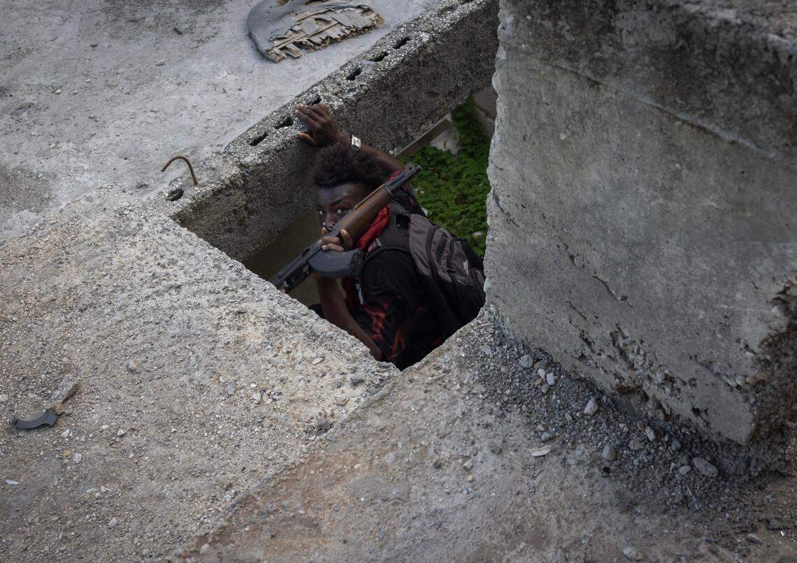 A gang member from the Viv Ansam coalition takes cover during a shoot-out with police in the Nazon neighborhood, Dec. 9, 2024.
