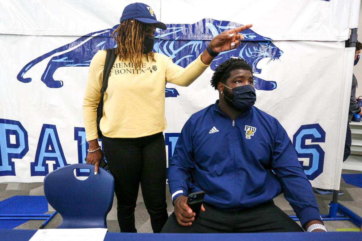 All-American defensive tackle Savion Collins and his mother Shauna Sampson, 45, look on after signing a national letter of intent to play college football for FIU.