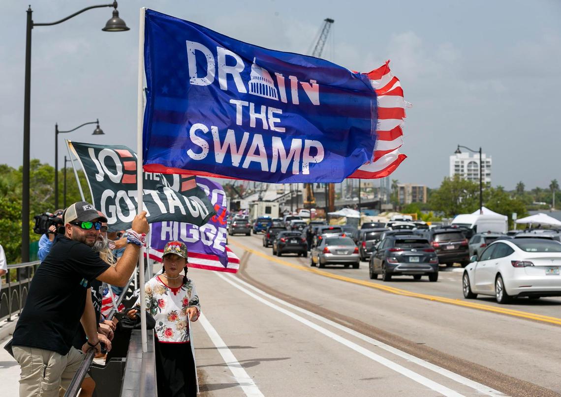 Jestin Nevarez, left, a supporter of former President Donald Trump, holds a flag near Mar-a-Lago on Tuesday, Aug. 9, 2022, in Palm Beach, Fla. The FBI conducted a search of Donald Trump’s Mar-a-Lago estate on Monday.
