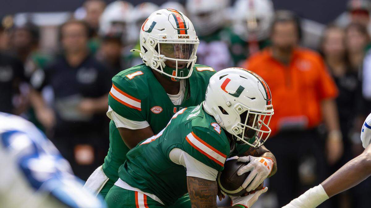 Miami Hurricanes quarterback Cam Ward (1) hand off the football to Hurricanes running back Mark Fletcher Jr. (4) during the first half of an ACC football game against the Duke Blue Devils at Hard Rock Stadium on Saturday, Nov. 2, 2024, in Miami Gardens, Fla.