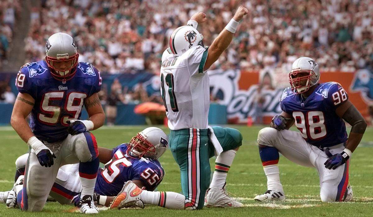 Patriots defensive team members (l-r) Andy Katzenmoyer, Willie McGinest, and Brandon Mitchell can only watch as Damon Huard celebrates after throwing a touchdown pass to Oronde Gadsden during the second quarter.