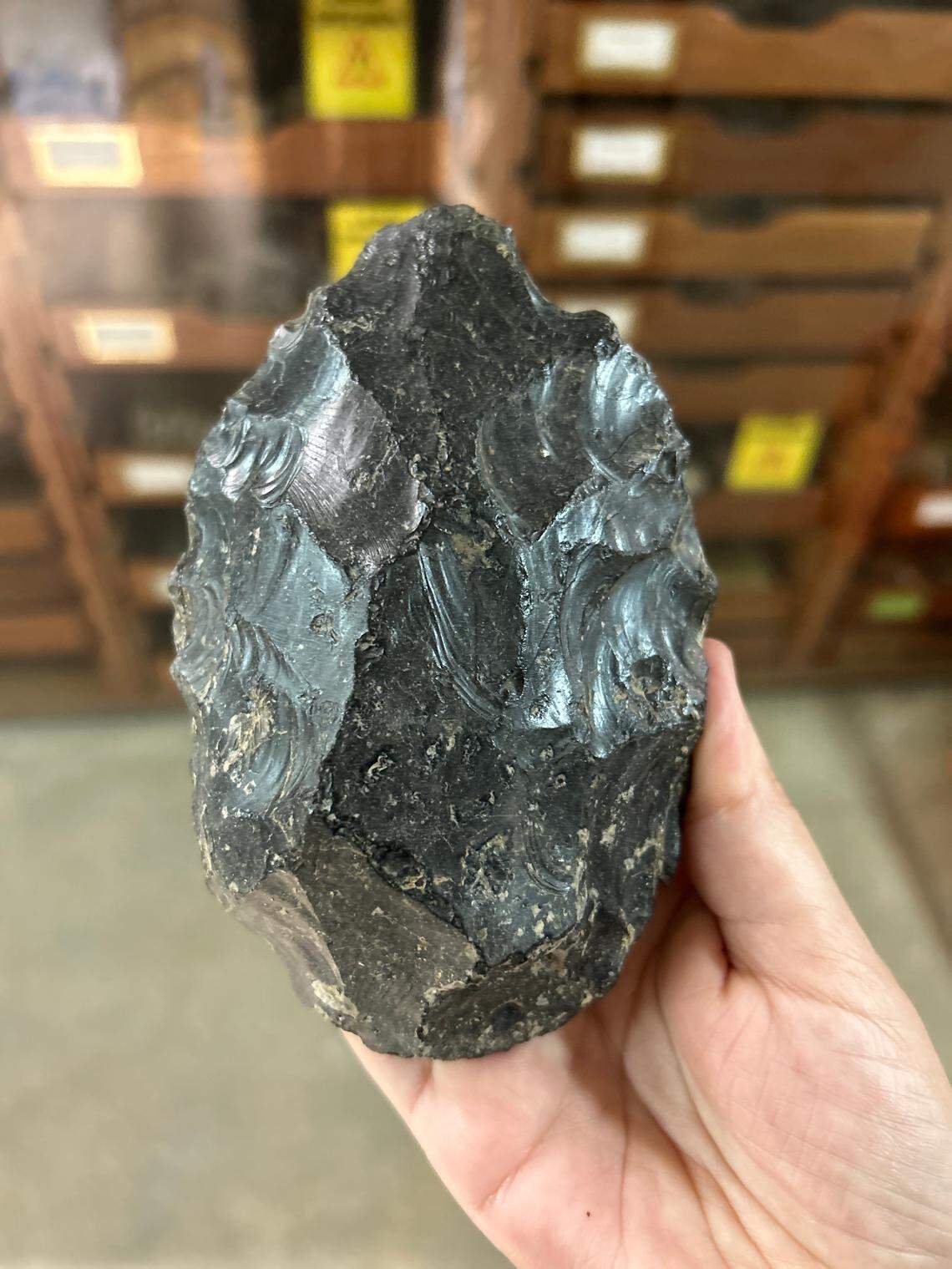 A researchers holds on of the obsidian handaxes found at the site.
