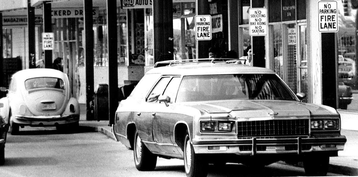 Illegally parked cars in 1977 at Westchester Shopping Center in front of Play World and Eckerd.