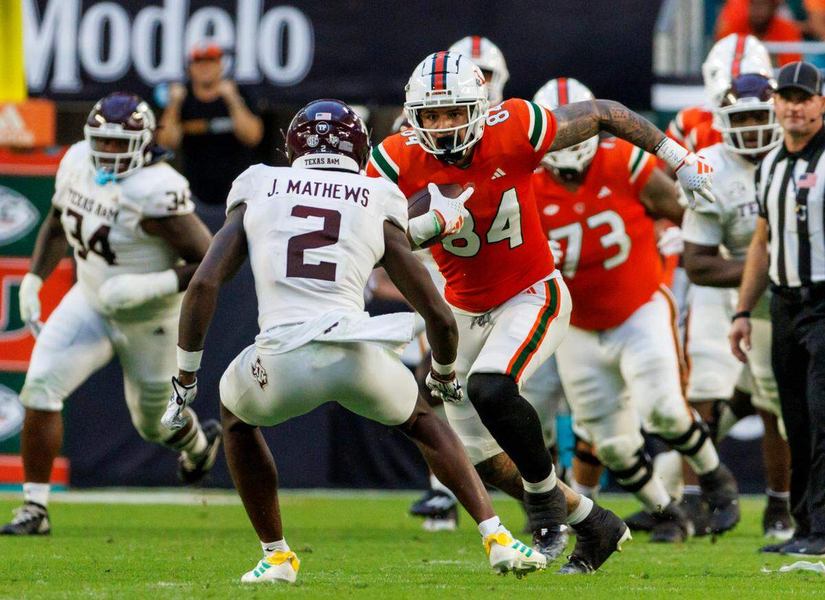 Miami Hurricanes tight end Cam McCormick (84) runs with the football as Texas A&M Aggies defensive back Jacoby Mathews (2) defends during the fourth quarter of an NCAA non conference game at Hard Rock Stadium on Saturday, Sept. 9, 2023 in Miami Gardens, Florida.