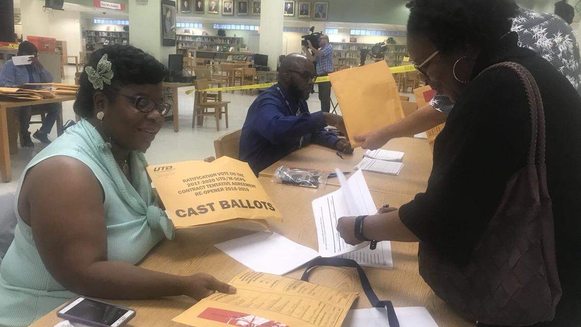 Joyce Harden, an organizer with United Teachers of Dade, accepts ballots from Misty Jackson, the union steward at William Lehman Elementary in Kendall. UTD tallied ballots from a ratification vote among its teachers Thursday at Miami Jackson Senior High.