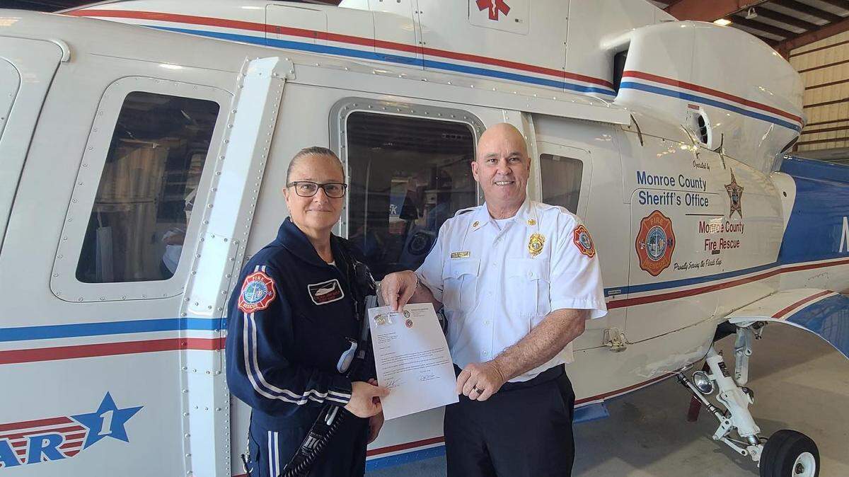 En esta foto de abril de 2022 publicada en la página de Facebook de los bomberos del Condado Monroe, Lynda Rusinowski recibe un reconocimiento por sus cinco años de servicio en el programa de ambulancias aéreas Trauma Star en los Cayos de la Florida. En ese momento era la enfermera jefa de transporte aéreo.