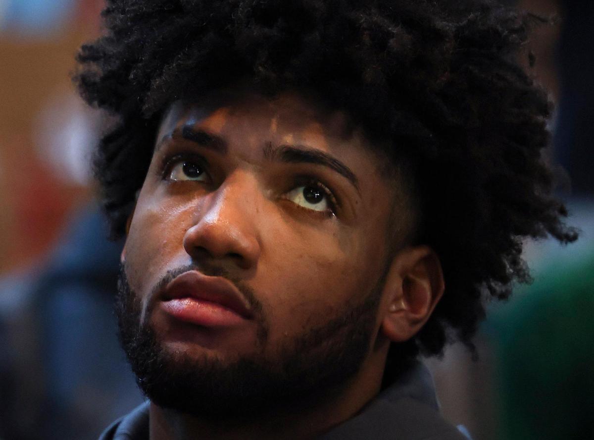 Norchad Omier watches the results during a watch party to decide where the Miami Hurricanes fall in the NCAA Tournament bracket on Sunday, March 12, 2023, in Coral Gables. Omier hurt his ankle in the last game.