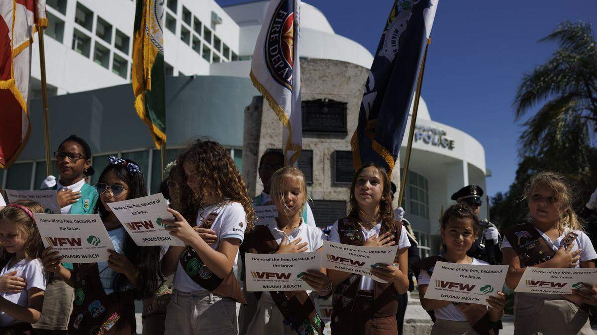 The Girl Scout Troop 2417 Brownies, along with the younger Daisy's, lead the Pledge of Allegiance during a Memorial Day Commemoration on Monday, May 25, 2026, at Miami Beach Police Headquarters in Miami Beach, Fla. 