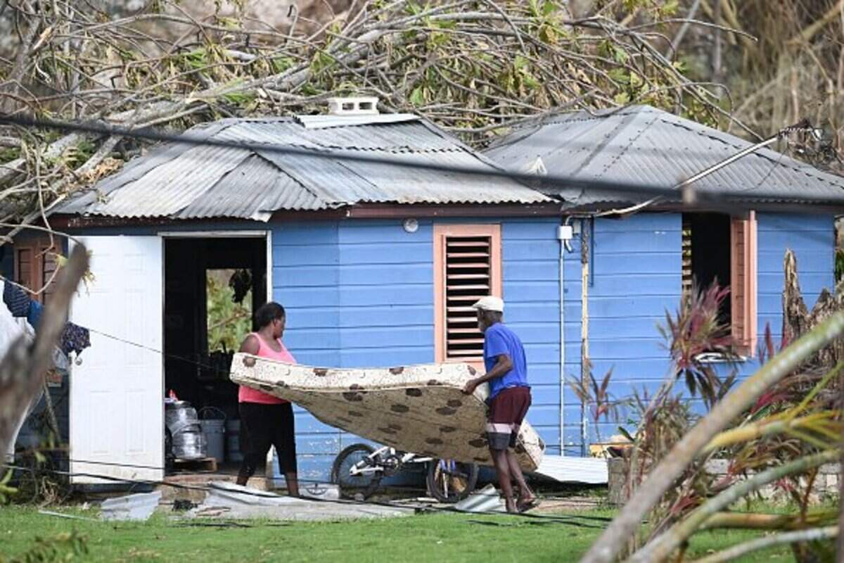 Residents move a mattress from damaged property in the aftermath of Hurricane Melissa in the community of Cave in Westmoreland, Jamaica.