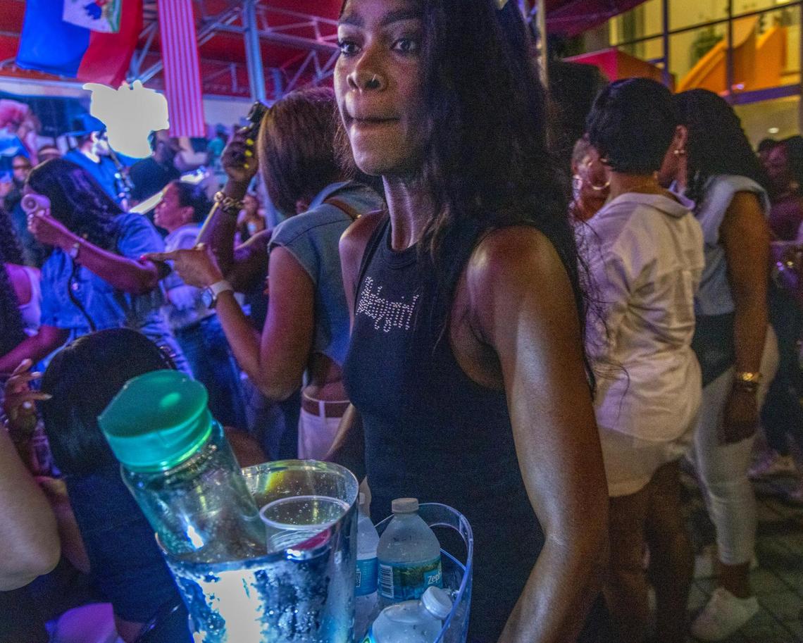 A host serves VIPs as Haitian konpa star Richard Cave and his band KAI perform during Sounds of Little Haiti, one of the center’s most popular events. 