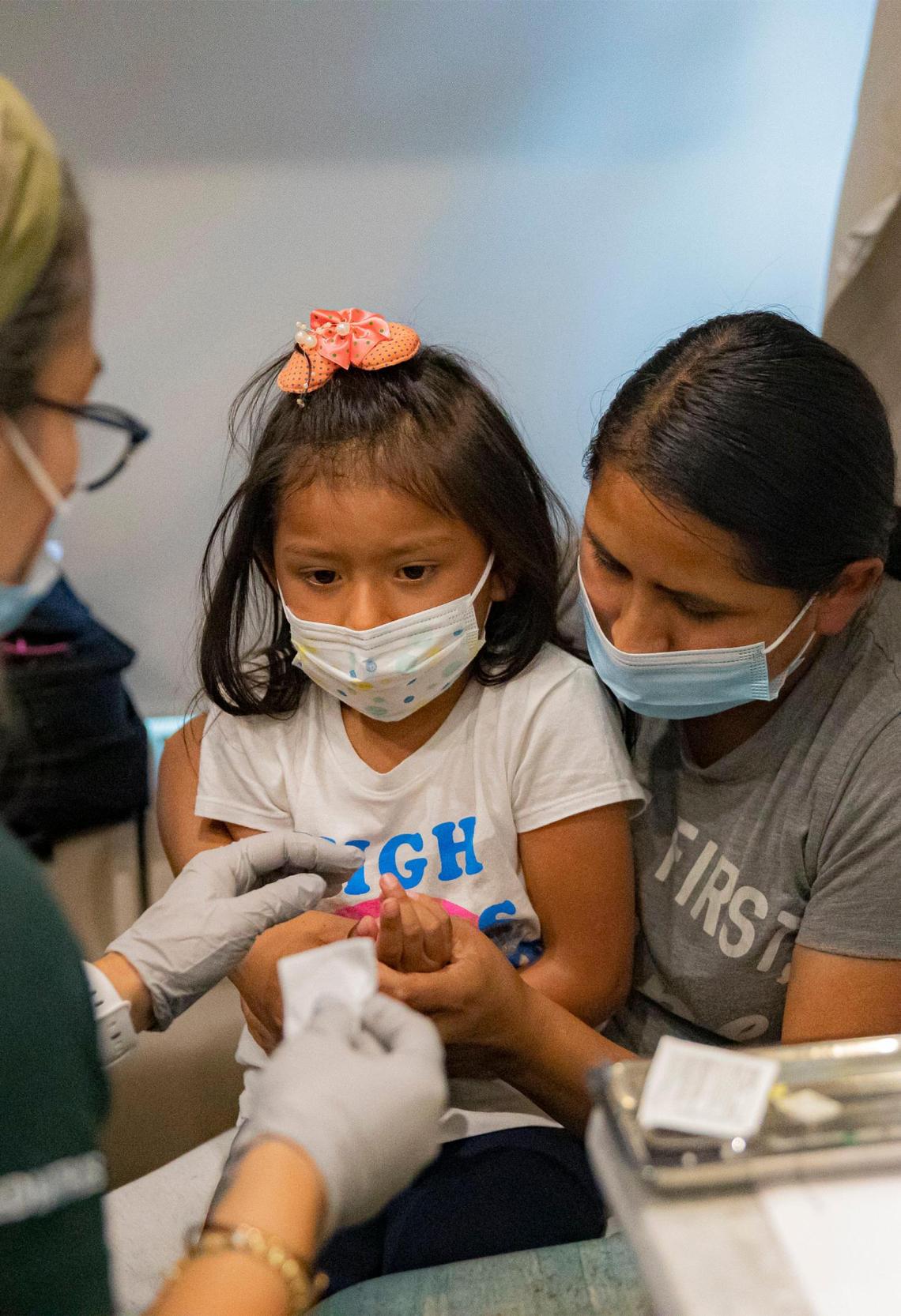 Saory Betalleluz, 5, sits with her mother, Julie Machaca, while receiving a vaccine at the University of Miami Pediatric Mobile Clinic in Homestead on Friday, June 24, 2022. Beginning Monday, June 27, 2022, children under 5 years old will be able to receive COVID-19 vaccinations at the University of Miami Pediatric Mobile Clinic.