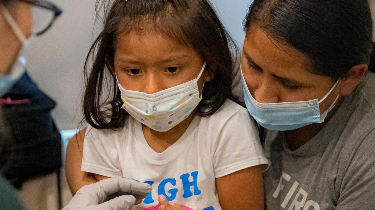 Saory Betalleluz, 5, sits with her mother, Julie Machaca, while receiving a shot at the University of Miami Pediatric Mobile Clinic in Homestead, Fla. on Friday, June 24, 2022.