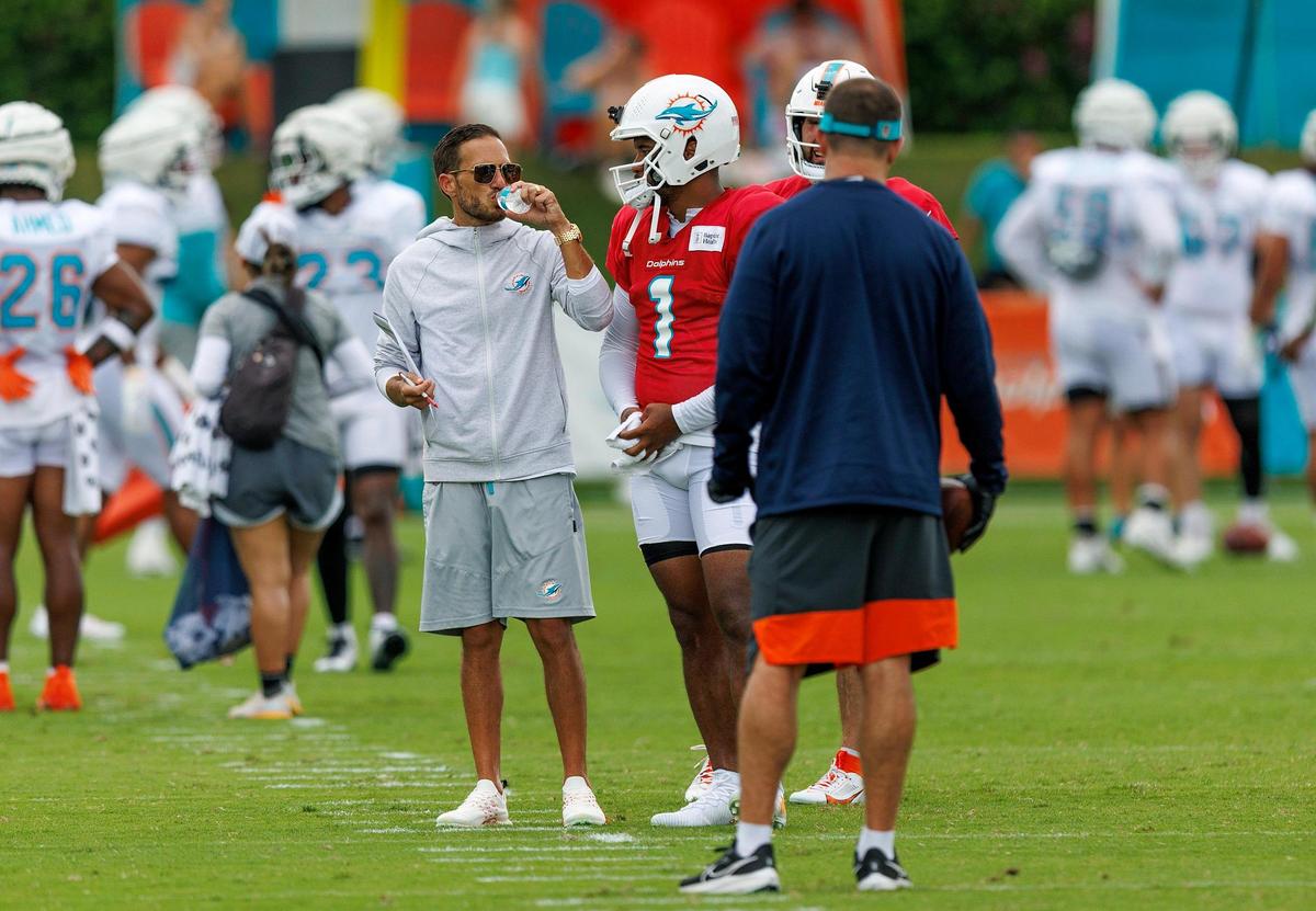 Miami Dolphins head coach Mike McDaniel talks with Dolphins quarterback Tua Tagovailoa (1) during NFL football training camp at Baptist Health Training Complex in Hard Rock Stadium on Tuesday, August 1, 2023 in Miami Gardens, Florida.
