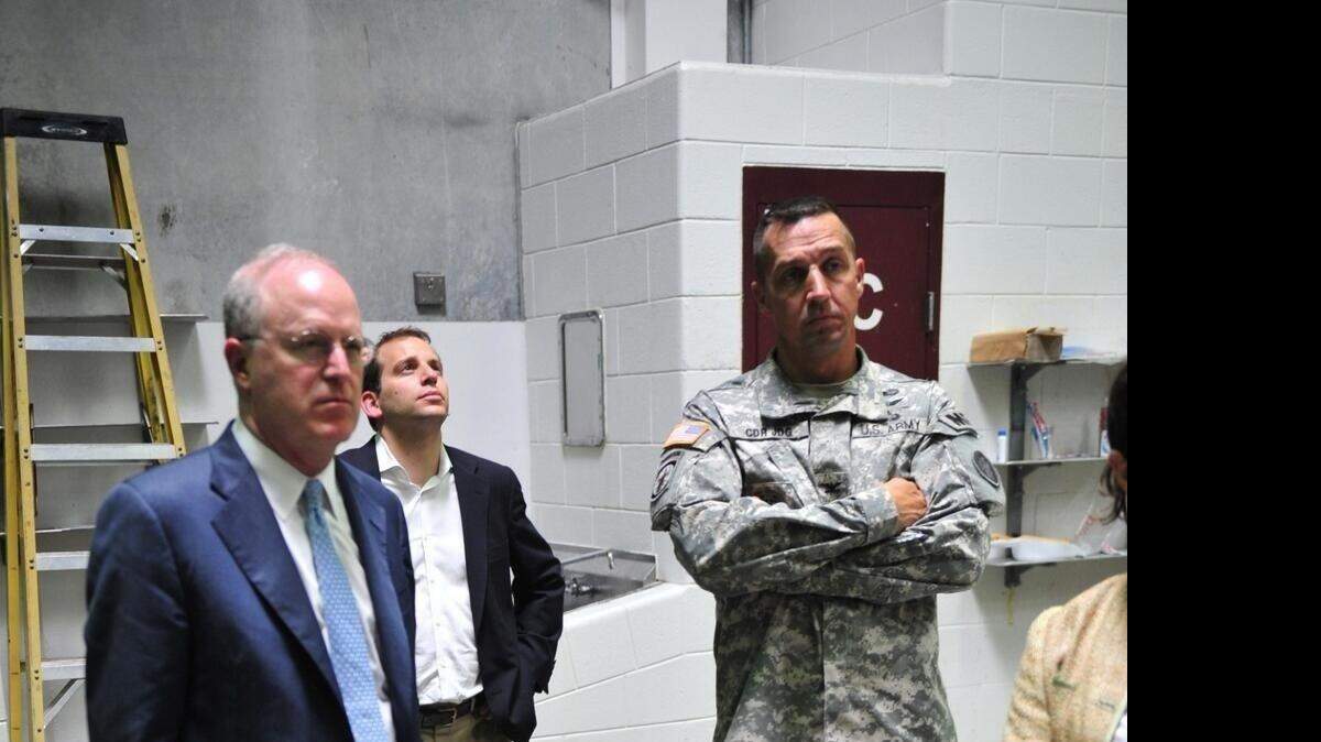 Army Col. John Bogdan, arms crossed, accompanies State Department special envoy Cliff Sloan inside Camp 6 in the Guantanamo prison camp handout photo released July 3, 2013, a day after Sloan's visit.