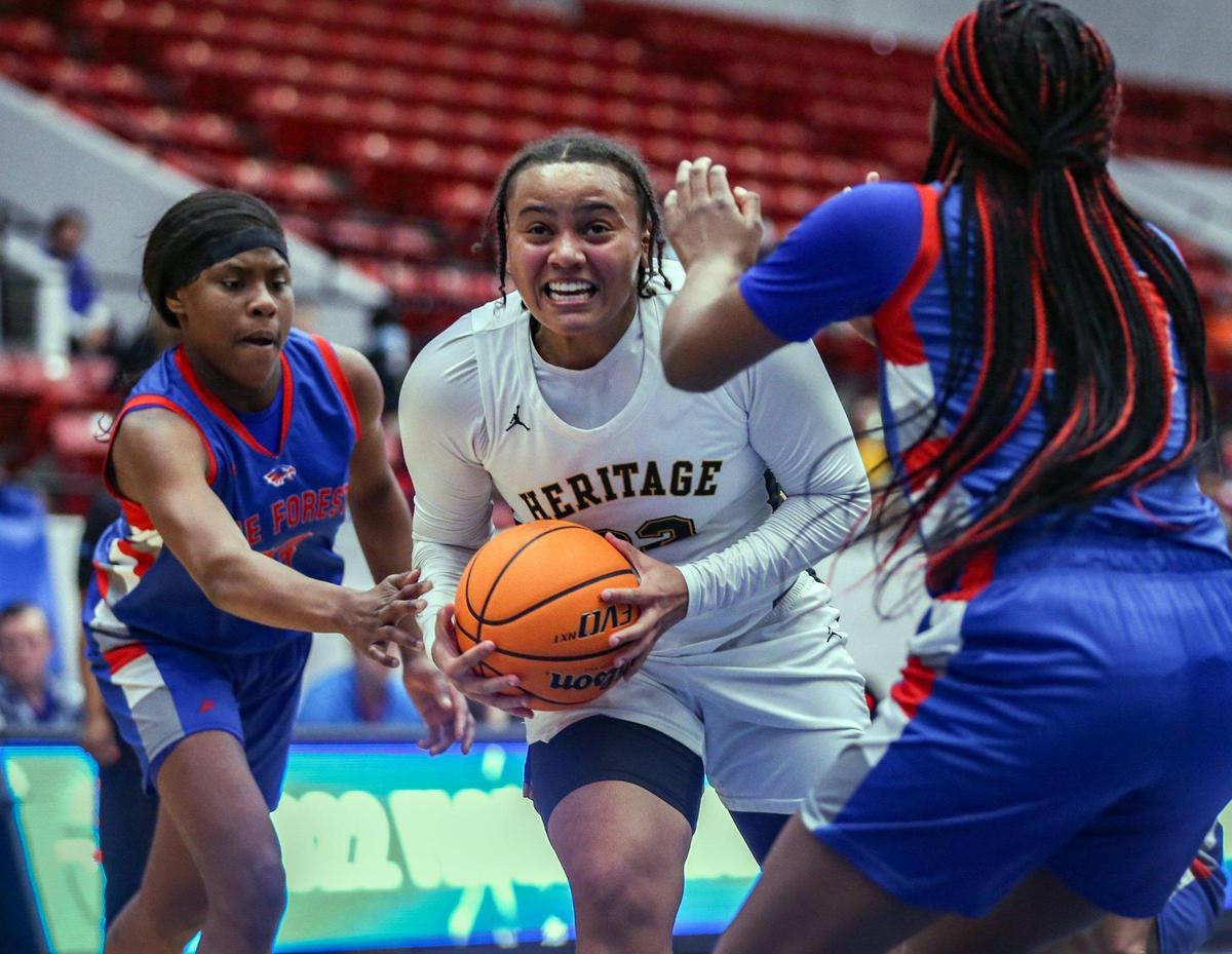 American Heritage guard Joey Delancy (22) battles Pine Forest defenders as she drives to the basket in a girls basketball Class 5A state semifinal at the RP Funding Center in Lakeland on Thursday, February 24, 2022.