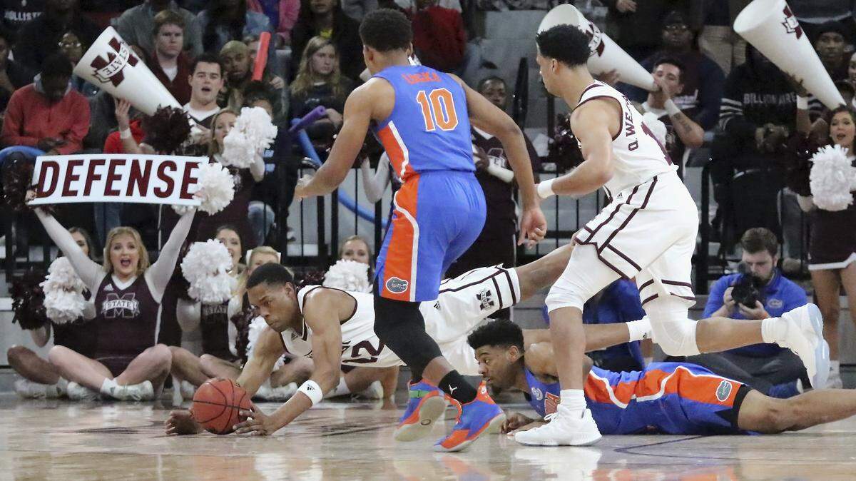 Mississippi State guard Robert Woodard (12) dives for a loose ball ahead of teammate Quinndary Weatherspoon (11) and Florida defenders Noah Locke (10) and Jalen Hudson (3) in the first half Tuesday, Jan. 15, 2019, in Starkville, Miss.