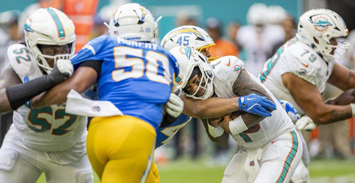 Miami Dolphins quarterback Tua Tagovailoa (1) is sacked by Los Angeles Chargers linebacker Tuli Tuipulotu (45) in the second half of their NFL game at Hard Rock Stadium on Sunday, Oct. 12, 2025, in Miami Gardens, Fla.