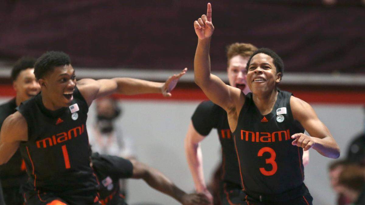 Miami’s Charlie Moore (3) right, celebrates with Anthony Walker (1) left, and Sam Waardenburg (21) after making the winning shot at the buzzer to end second half of an NCAA college basketball game against Virginia Tech, Wednesday, Jan. 26 2022, in Blacksburg Va. (Matt Gentry/The Roanoke Times via AP)