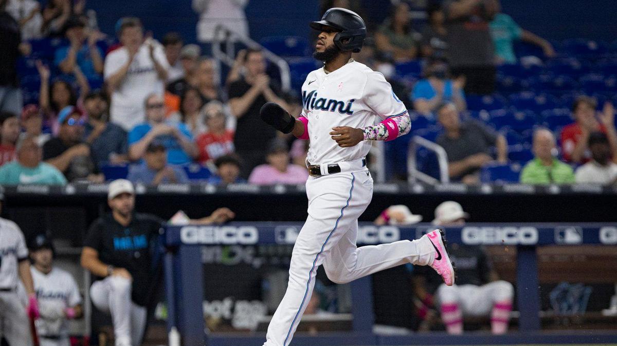 Miami Marlins left fielder Bryan De La Cruz (14) crosses home plate after Miami Marlins third baseman Jean Segura (9) gets an RBI during the sixth inning of a baseball game between the Miami Marlins and the Cincinnati Reds on Sunday, May 14, 2023, at loanDepot Park in Miami.