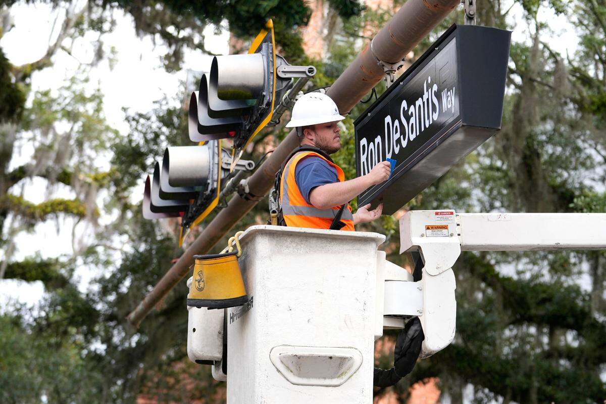 Zackary Atkins hangs a street sign with the name of Florida Gov. Ron DeSantis in preparation for the inauguration of the governor, Monday, Jan. 2, 2023, at the Historic Capitol in Tallahassee.