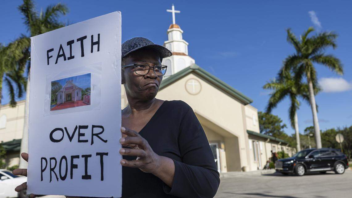Jennifer Howard holds a sign protesting the sale of her church outside the House of God Church in Pompano Beach. Members of South Florida congregations organized the protest after learning that longtime churches were being sold for what they say is below market value.
