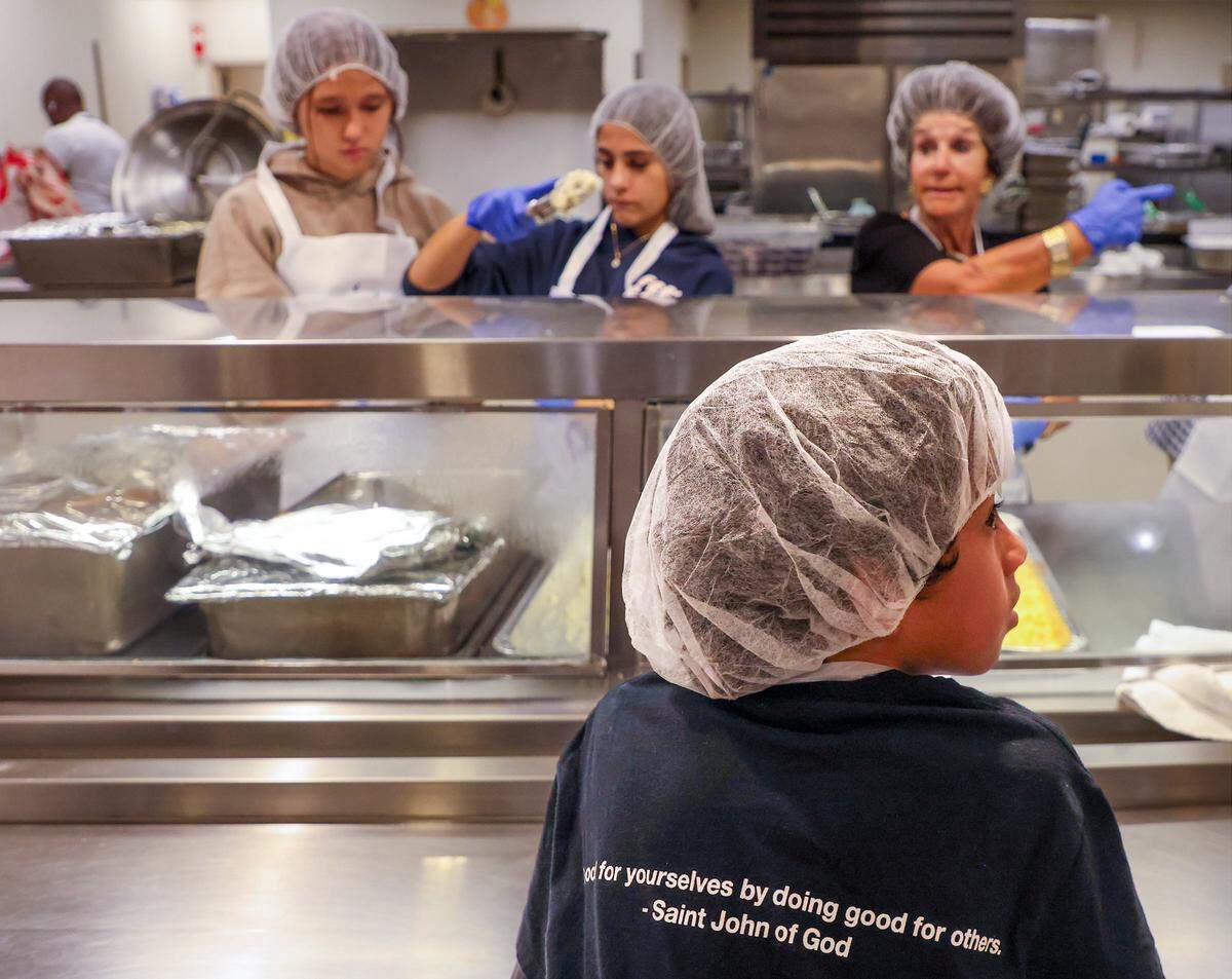 Volunteers serve and distribute meals to hundreds of clients for Thanksgiving.  Camillus House held its 65th annual Thanksgiving Celebration, a cherished tradition that brings hope, dignity, and fellowship to hundreds of individuals experiencing shelter insecurity with a Thanksgiving dinner and other activities at its main campus on Thursday, November 27, 2025, in Miami, Florida. 