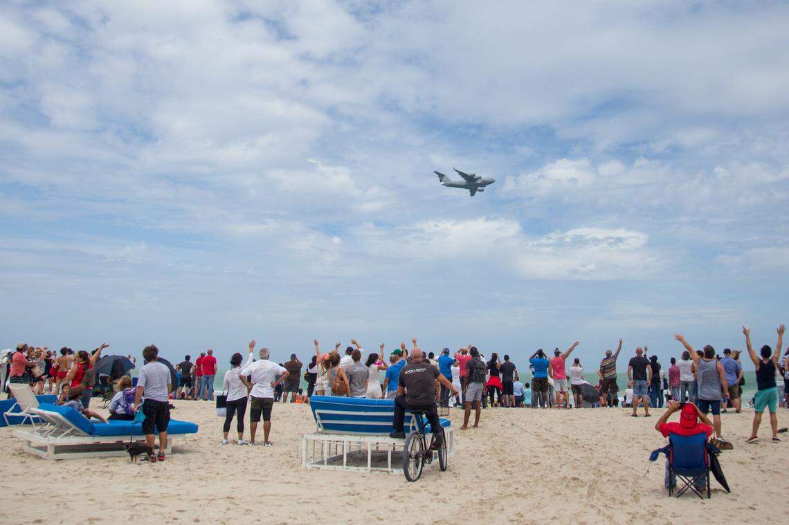 The crowd on the beach waves at a United States Air Force plane flying past during the Hyundai Air & Sea show in Miami Beach on Sunday, May 27, 2018.