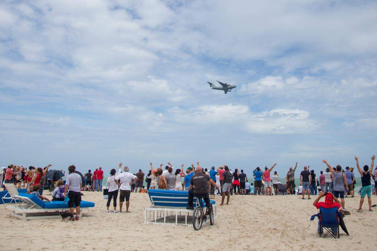 A crowd of people waves at a United States Air Force plane flying over the beach during the Hyundai Air & Sea Show in Miami Beach on Sunday, May 27, 2018. The annual military celebration will return to the Beach for Memorial Day Weekend 2021.