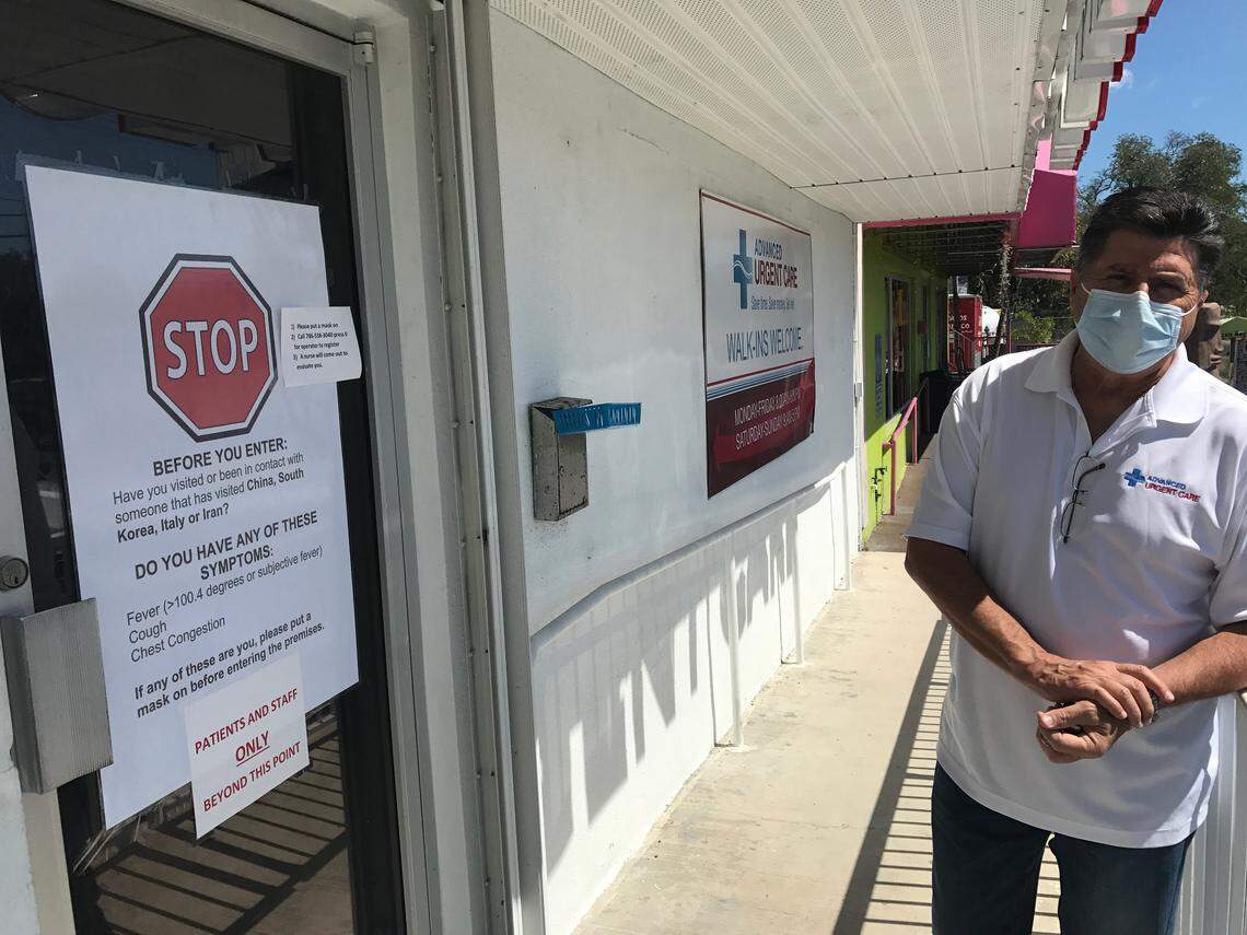 Dr. Bruce Boros, owner of Advanced Urgent Care of the Florida Keys, stands beside a sign in front of his Key Largo clinic on Thursday, April 2, 2020. The sign informs people that they must call before entering the clinic as part of the policy to prevent the spread of the novel coronavirus.