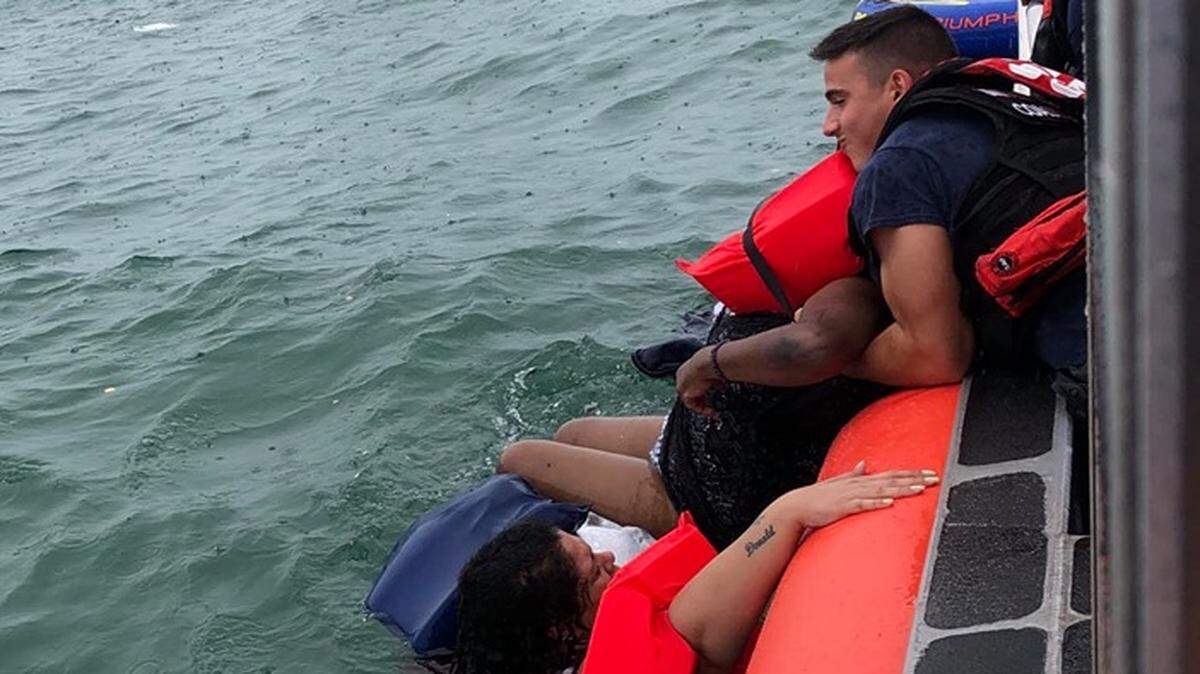 U.S. Coast Guard sailors from Station Islamorada pull people from the water off Snake Creek in the Florida Keys Sunday, June 16, 2019.