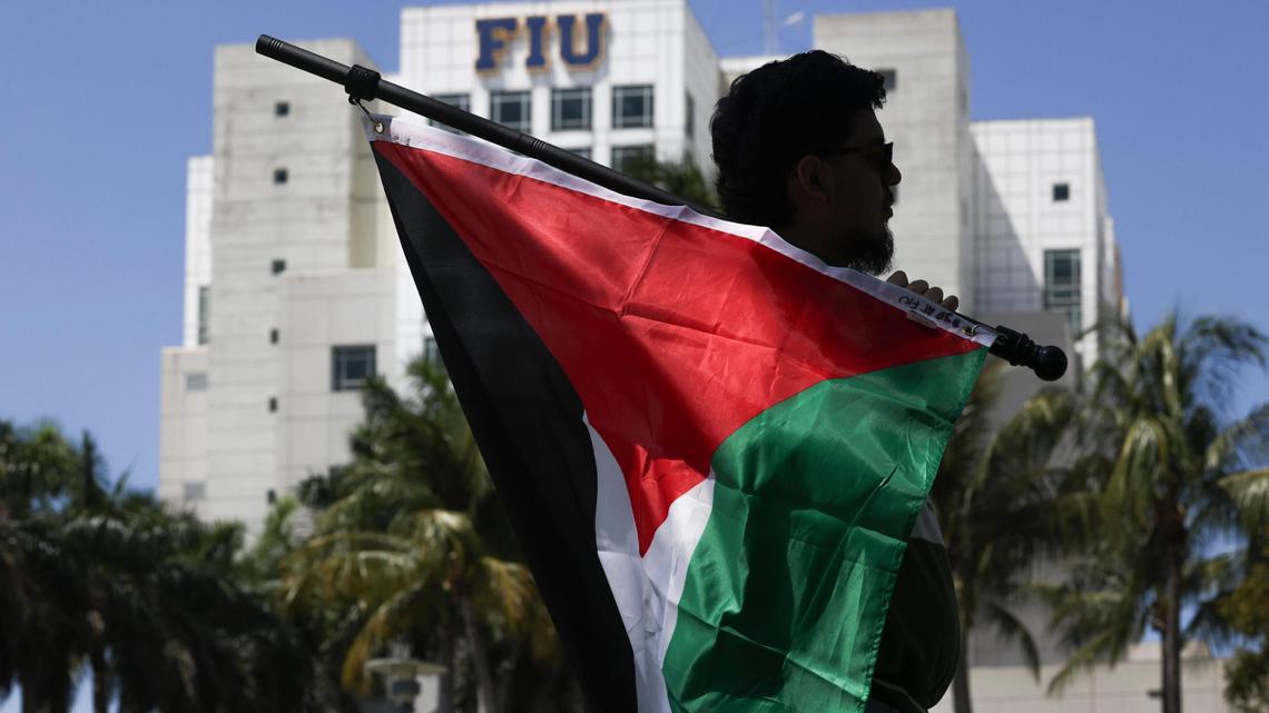 Tomas Jimenez holds a Palestinian flag during a gathering hosted by FIU students in support of Mahmoud Khalil, the Columbia student who faces deportation over his pro-Palestinian activism, on Wednesday, March 26, 2025, outside the Florida International University Ernest R.Graham Center in Miami.