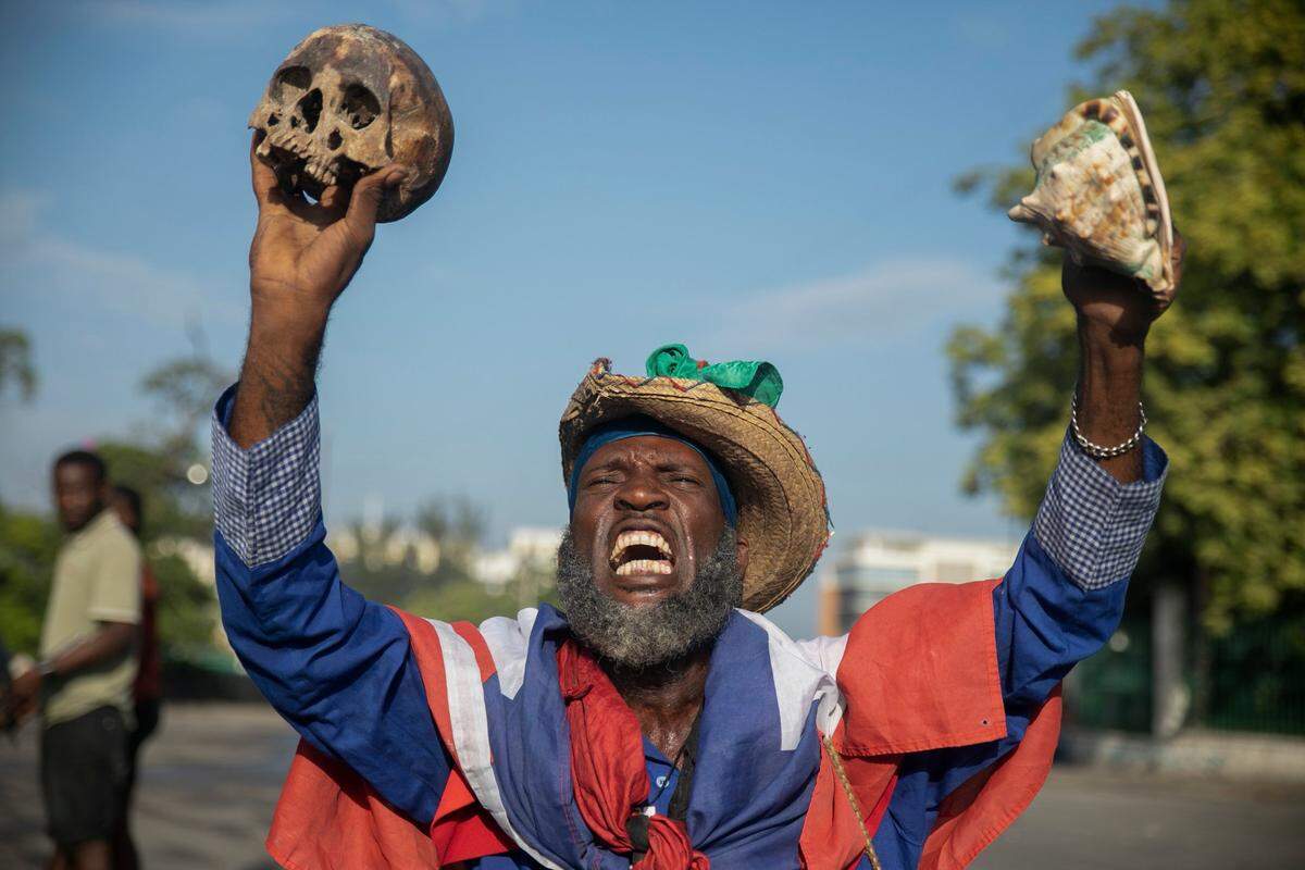 A protester holding up a skull and seashell shouts for the resignation of Haitian Prime Minister Ariel Henry in the street in the Champs de Mars area where the prime minister attended a ceremony marking the death anniversary of revolutionary leader Jean-Jacques Dessalines in Port-au-Prince, Haiti, Monday, Oct. 17, 2022. (AP Photo/Odelyn Joseph)