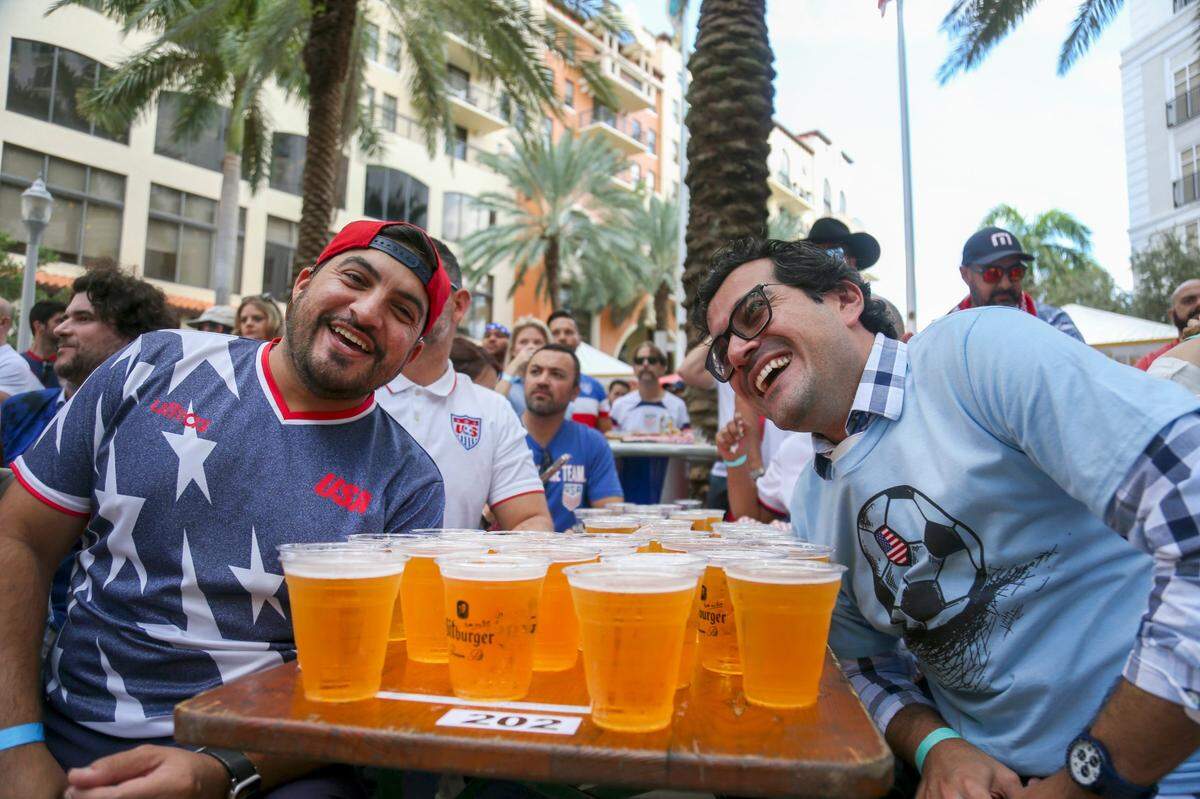 Victor Riobueno, left, and Jairo Villela enjoy the World Cup game between the United States and Iran during a watch party at Fritz & Franz Bierhaus in Coral Gables, Florida, on Tuesday, November 29, 2022.