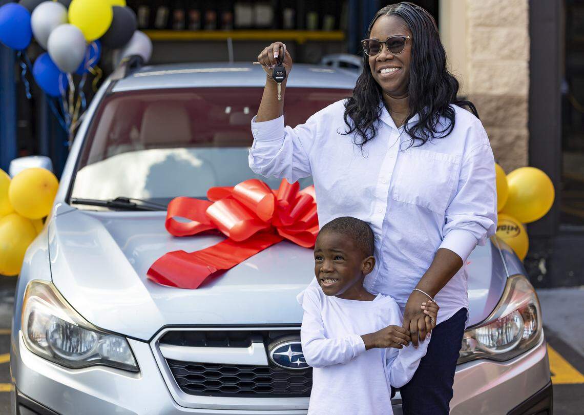 Kingston Allen, 4, and his mom, Renee King, 36, react as they inspect the refurbished Subaru Impreza they were gifted at a Midas on Thursday, Feb. 12, 2026, in Fort Lauderdale, Fla. King, a single mom with two children, was forced to give up her previous car and relied entirely on public transportation to get to work.