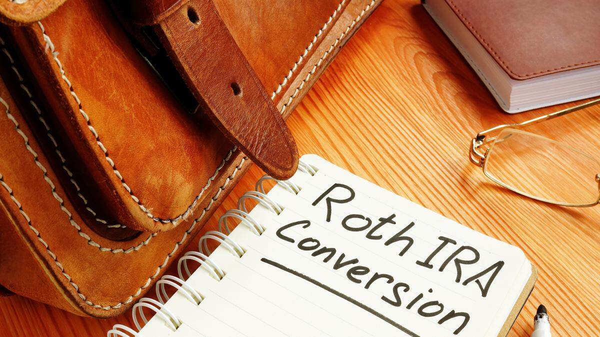 Roth ira conversion memo near retro briefcase and glasses.