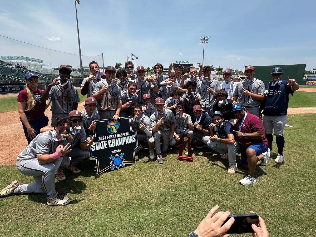 The Dwyer High School baseball team, coached by former Miami Marlins pitcher Jordan Yamamoto, poses with the trophy after winning the Class 6A state baseball championship on May 18 in Fort Myers, Fla.