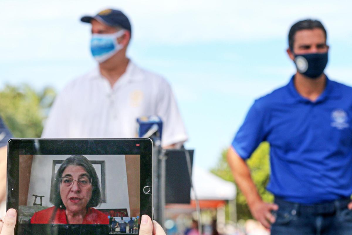 Miami-Dade County Mayor Daniella Levine Cava is seen through the screen of an iPad during a press conference with Mayor Dan Gelber of Miami Beach and Mayor Francis Suarez of the City of Miami at a food distribution site on 22nd Street and Collins Avenue in Miami Beach, Florida, on Saturday, December 5, 2020.