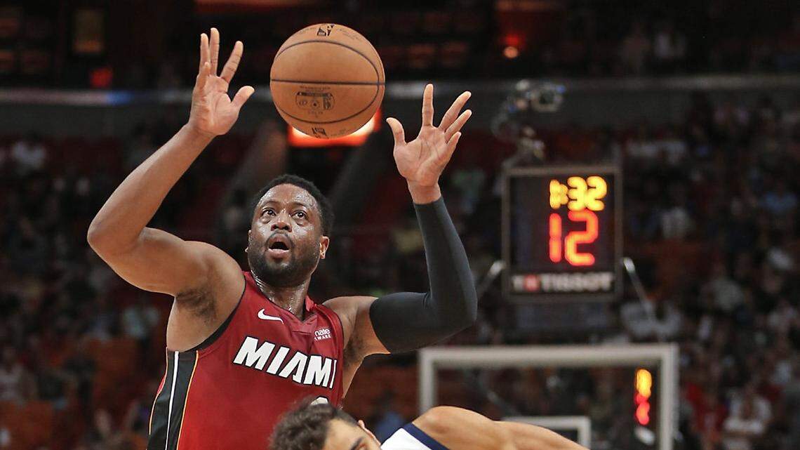 The Heat’s Dwyane Wade (3) gathers a loose ball from Utah’s Raul Neto (25) in the first quarter Sunday, Dec. 2, 2018, at the AmericanAirlines Arena in Miami.