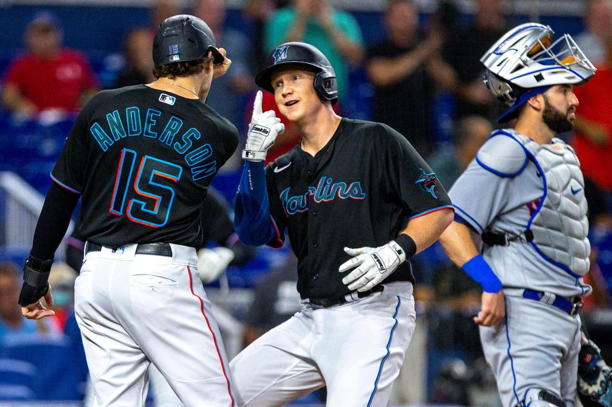 Miami Marlins batter Garrett Cooper (26) reacts with teammate Brian Anderson (15) after hitting a two-run home run during the first inning of an MLB game against the New York Mets at loanDepot park in the Little Havana neighborhood of Miami, Florida, on Friday, September 9, 2022.