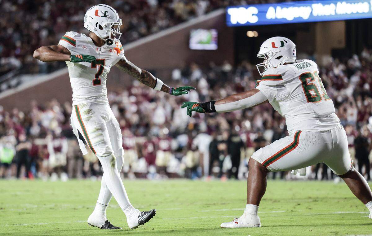 Miami Hurricanes wide receiver CJ Daniels (7) and offensive lineman Francis Mauigoa (61) celebrate after Daniels scores in the first half of the NCAA game against the Florida State Seminoles at Doak Campbell Stadium in Tallahassee, Florida, on Saturday, October 4, 2025.