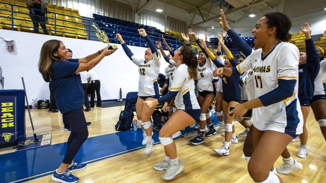 St. Thomas Aquinas girls volleyball players react with Assistant Athletic Director Lisa Zielinski after winning the BCAA Big 8 Championship over South Plantation at Pompano Beach High in Pompano Beach, Florida, on Thursday, October 13, 2022.