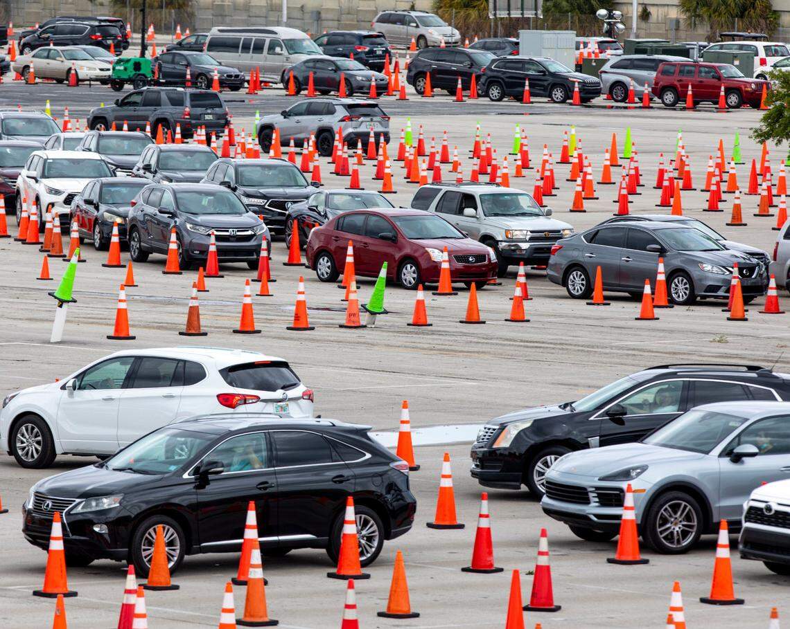 People line up in their cars to get vaccinated at Hard Rock Stadium in Miami Gardens, Florida, on Monday, April 12, 2021. The site will no longer require appointments and has expanded COVID vaccine hours.