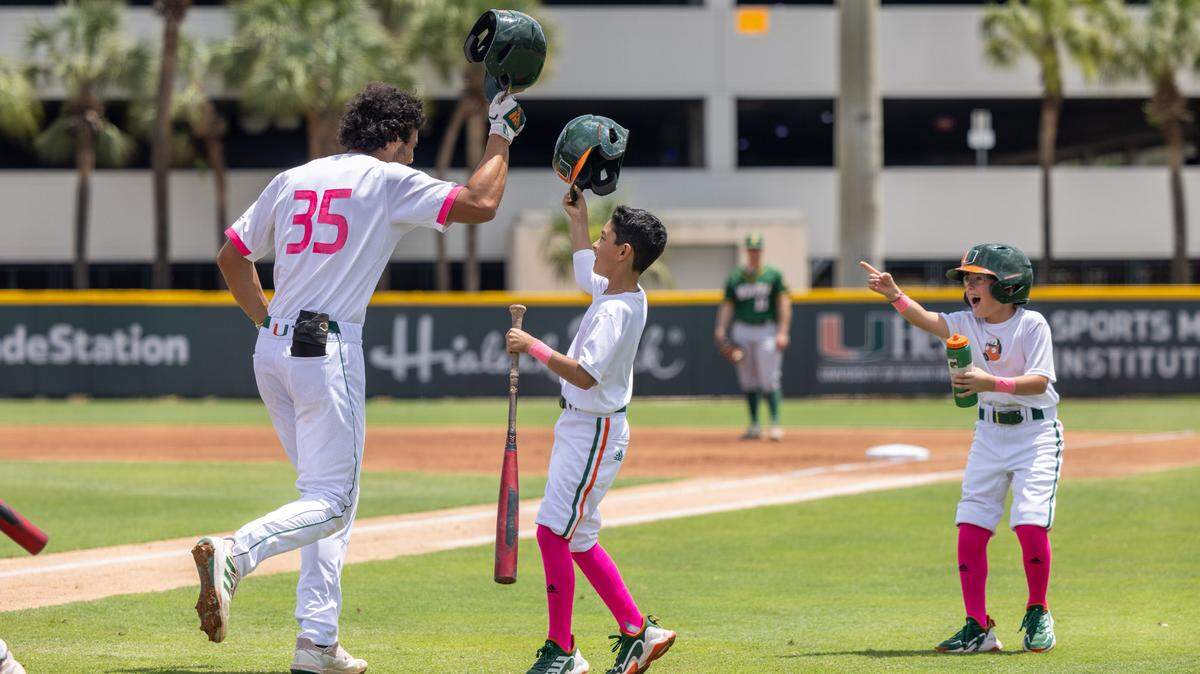 Yohandy Morales celebrates with UM batboys Jon Michael Quijano (left) and Kam Clute after hitting a home run against North Dakota State on Sunday, May 8, 2022