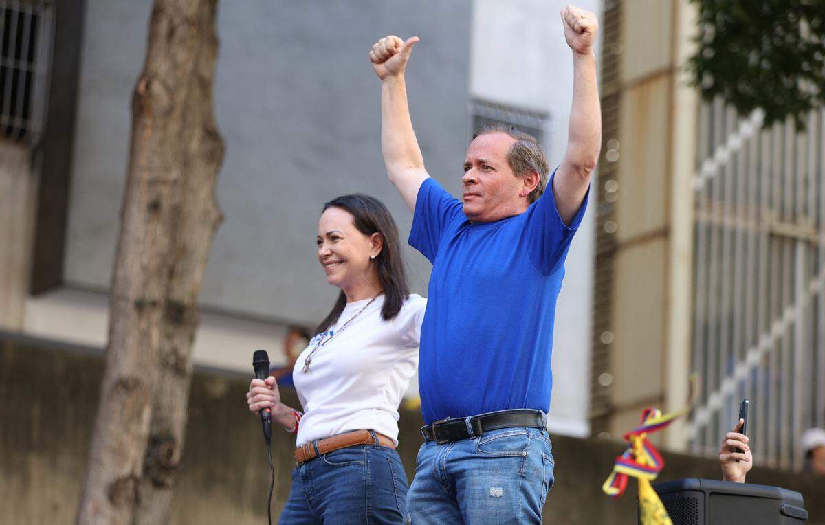 Former Deputy of the National Assembly of Venezuela, Juan Pablo Guanipa (R) gestures next to Venezuelan opposition leader Maria Corina Machado during a protest called by the opposition on the eve of the presidential inauguration in Caracas on January 9, 2025. Machado, who emerged from hiding to lead protests against the swearing-in of Nicolas Maduro for a highly controversial third term as president, was arrested after being “violently intercepted upon exiting the rally,” according to her security team. (Photo by Pedro MATTEY / AFP) (Photo by PEDRO MATTEY/AFP via Getty Images)