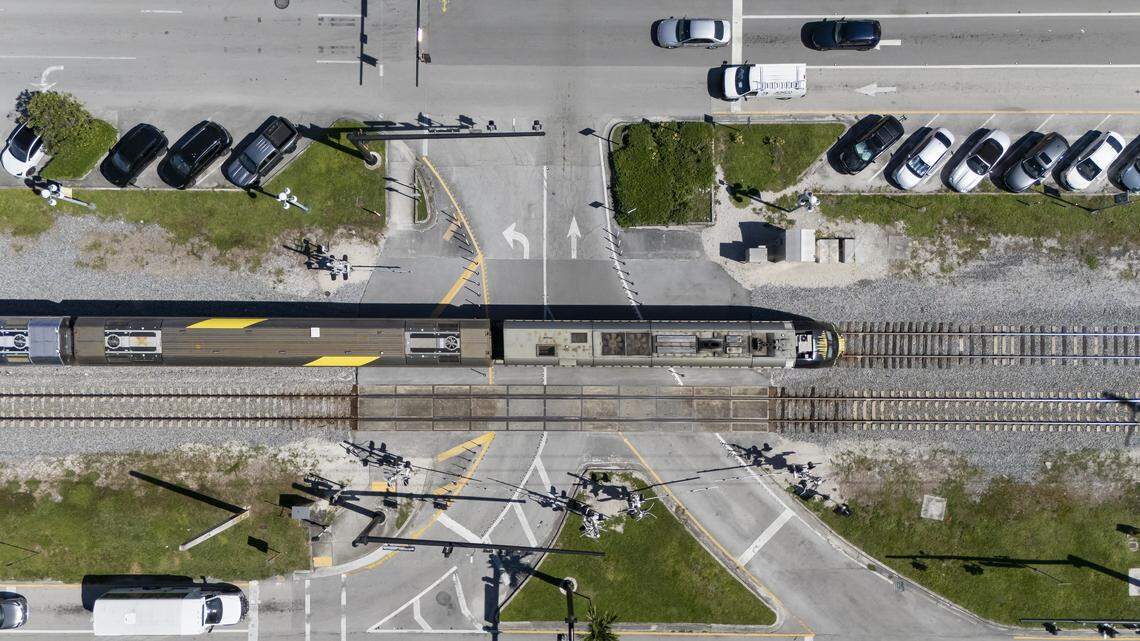 A Brightline train moves along tracks at the Harrison Street rail crossing in Hollywood, Florida.