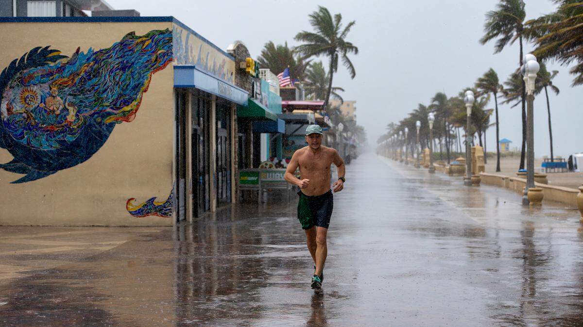 Pavel Matorny of South Florida runs through the rain along the Hollywood Beach Broadwalk on Monday, May 12, 2025. The National Weather Service in Miami forecasts widespread showers and thunderstorms throughout the day, with a 90% chance of precipitation and 1 to 3 inches of rain expected by Tuesday morning.